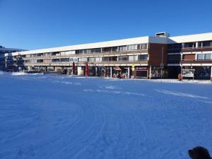 a snow covered parking lot in front of a building at Le Flocon - Chamrousse 1750 - Sur les pistes in Chamrousse