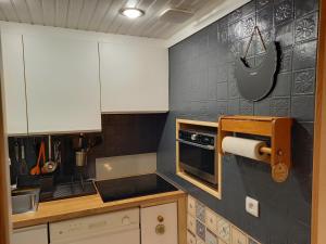 尚魯斯的住宿－Le Flocon - Chamrousse 1750 - Sur les pistes，厨房配有白色橱柜和炉灶烤箱。