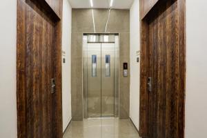 Ramya Residency Navi Mumbai في نافي مومباي: مصعد بأبواب خشبية في مبنى