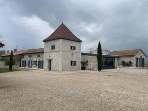 a large white building with a brown roof at Demeure charentaise Standing - Grande Piscine - jacuzzi balnéo - Pool house in Barbezieux-Saint-Hilaire