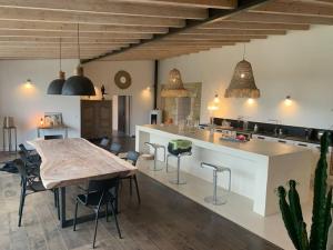 uma cozinha com uma mesa de madeira e uma sala de jantar em Demeure charentaise Standing - Grande Piscine - jacuzzi balnéo - Pool house em Barbezieux