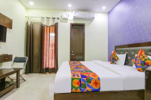 a hotel room with a bed and a table and a desk at FabExpress Kohinoor City in Chandīgarh
