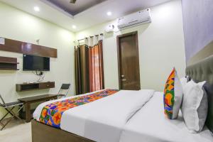 a bedroom with a bed and a desk and a television at FabExpress Kohinoor City in Chandīgarh