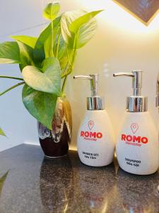 three soap dispensers sitting on a counter with a plant at Romo Homestay in Quang Ngai