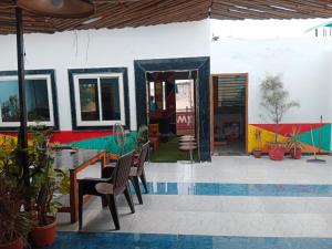 un patio con mesa, sillas y piscina en Bedweiser Backpackers Hostel en Agra