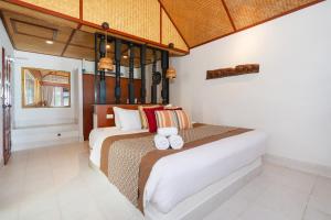 een slaapkamer met een bed met twee handdoeken erop bij Friendship Beach Resort & Atmanjai Wellness Centre in Rawai Beach