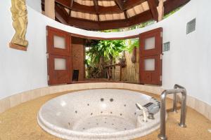a large bath tub in a room with a large window at Friendship Beach Resort & Atmanjai Wellness Centre in Rawai Beach
