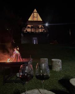 zwei Gläser Wein vor einer Feuerstelle in der Unterkunft Columbus Villas in Vermosh