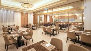a dining room with tables and chairs and a restaurant at Mercure Ambassador Jeju in Seogwipo