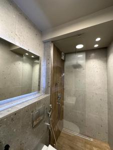 La salle de bains est pourvue d'une douche avec une porte en verre. dans l'établissement Art apartment Pamporovo Grand Monastery, à Pamporovo