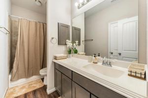 a bathroom with a sink and a toilet and a mirror at Wonderful Getaway Cypress 2 BR with thoughtful comforts in Cypress