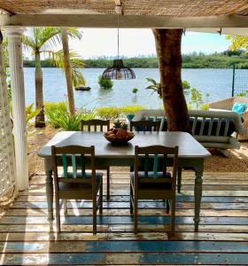 - une table et des chaises sur une terrasse avec vue sur l'eau dans l'établissement La Cabane du Pecheur, à Rivière Noire