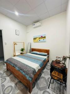 ein Schlafzimmer mit einem Bett und einem Tisch darin in der Unterkunft Homestay Bốn Mùa Phan Thiết in Ấp Sung Xuân