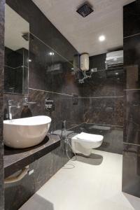 a bathroom with a sink and two toilets in it at Ramya Residency Navi Mumbai in Navi Mumbai