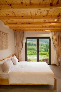 Lat Valley Village في Dankia: غرفة نوم بسرير كبير مع نافذة كبيرة