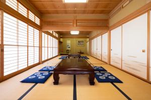 Habitación con mesa y alfombras azules en el suelo en -izen 高田- 柳精庵, en Joetsu