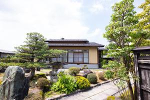 un jardín japonés frente a un edificio en -izen 高田- 柳精庵, en Joetsu