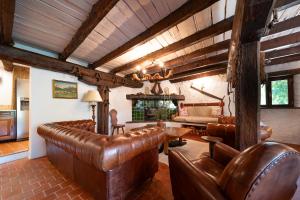 een woonkamer met leren banken en een tafel bij Chalet La Foux - Ancienne ferme rénovée in Allos