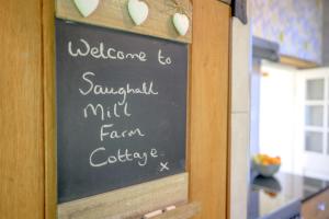 een schoolbord met een welkom voor Savannah Mill Farm Collection bij Saughall Mill Farm Cottage in Chester