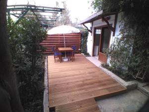een houten terras met een tafel en een parasol bij UzHan Beach Hotel in Bitez