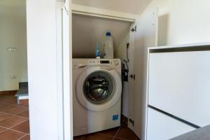 una sala de lavandería con lavadora en una habitación en Agriturismo La Grotta en San Giuliano Terme