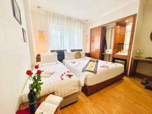 a hotel room with two beds and a window at Elite Central Hotel Hanoi in Hanoi