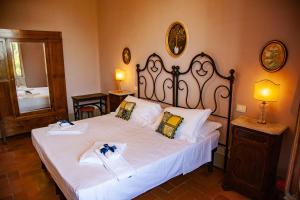 una camera da letto con un grande letto con lenzuola bianche di Agriturismo Villa Ulivello in Chianti a Strada