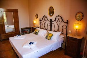 ein Schlafzimmer mit einem großen Bett mit weißer Bettwäsche in der Unterkunft Agriturismo Villa Ulivello in Chianti in Strada