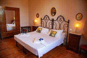 a bedroom with a large bed with white sheets at Agriturismo Villa Ulivello in Chianti in Strada