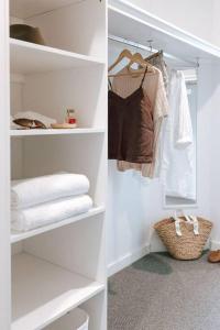 a white walk in closet with towels and clothes at Omaru Beach House in Scamander
