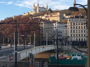 a bridge over a river in a city with buildings at Chambre B&B dans appartement vue Saône calme absolu in Lyon