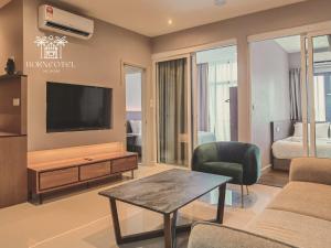 un soggiorno con TV, divano e tavolo di Borneotel The Shore KK by CHG a Kota Kinabalu