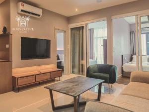 a living room with a tv and a couch and a table at Borneotel The Shore KK by CHG in Kota Kinabalu