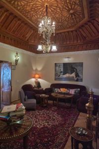 a living room with a couch and a chandelier at Riad Thamayna in Sale