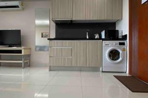 a kitchen with a washing machine and a tv at Laguna Beach Resort 1 by BPS in Jomtien Beach +17 photos