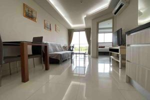 a living room with a couch and a table and a television at Laguna Beach Resort 1 by BPS in Jomtien Beach
