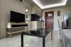 a living room with a tv and a glass table at Laguna Beach Resort 1 by BPS in Jomtien Beach