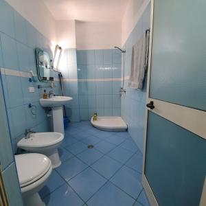 een blauwe badkamer met 2 toiletten en een wastafel bij Rent Apartament Bardho in Durrës