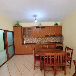 een keuken met een houten tafel en een aantal stoelen bij Rent Apartament Bardho in Durrës