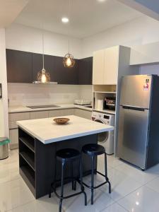 una cocina con una isla con 2 taburetes en Lexa Residences at KL, en Kuala Lumpur