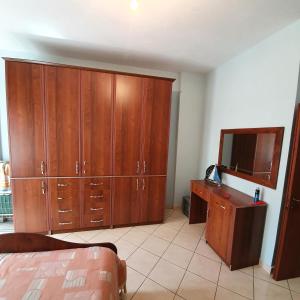 een slaapkamer met houten kasten, een bureau en een televisie bij Rent Apartament Bardho in Durrës