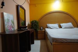 1 dormitorio con 1 cama y vestidor con espejo en Dmello Guest House en Canacona