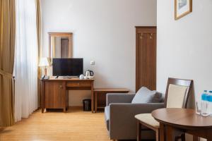 a living room with a couch and a desk with a television at Hotel Kresowiak in Siemiatycze