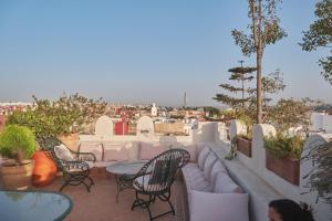 a patio with couches and tables and chairs on a roof at Riad Thamayna in Sale