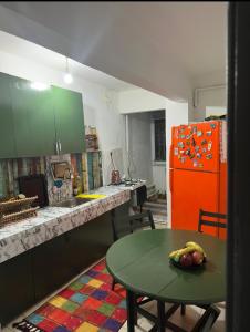 a kitchen with a green table and an orange refrigerator at single room, in Üsküdar in Istanbul