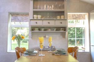 a dining room with a table and chairs and windows at Saughall Mill Farm Cottage in Chester
