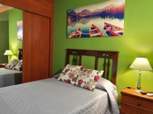een slaapkamer met een bed en een foto van boten bij Casa Bracamonte in Mondoñedo