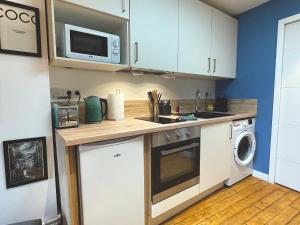 eine Küche mit einer Spüle und einer Mikrowelle in der Unterkunft Studio de charme sous les toits #6 in Dreux