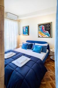 um quarto com uma grande cama azul com almofadas azuis em panoramic luxury penthouse 6 people em Milão