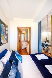 a bedroom with a large bed with blue pillows at panoramic luxury penthouse 6 people in Milan